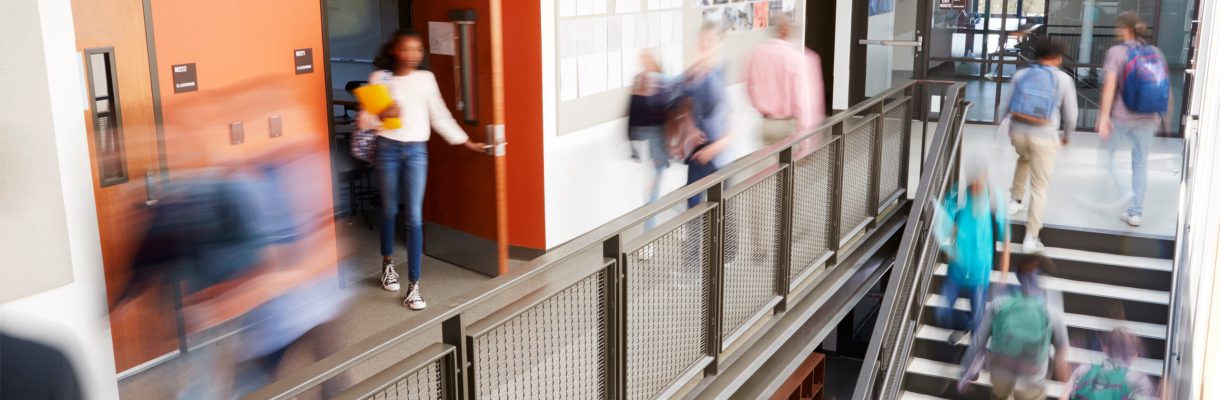 Busy High School Corridor During Recess With Blurred Students And Staff